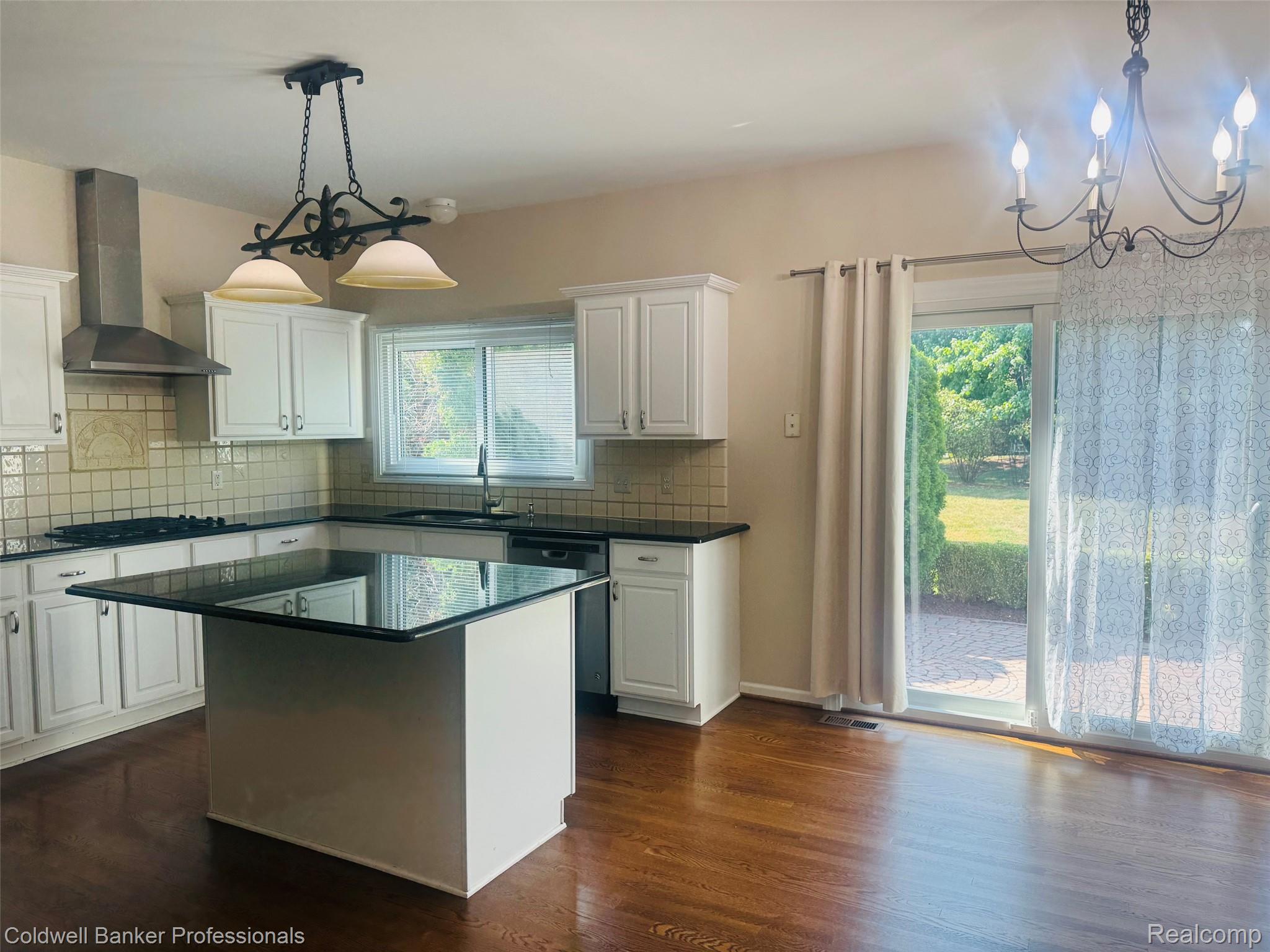 171 Millstone Road Troy, MI 48084 - Photo 16 of 43 Kitchen featuring white cabinetry, dark countertops, tile backsplash, and wood-finish flooring