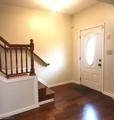 a view of a hallway with wooden floor and entryway