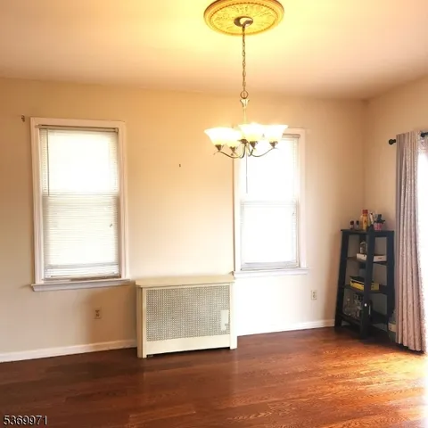 an empty room with wooden floor and a window