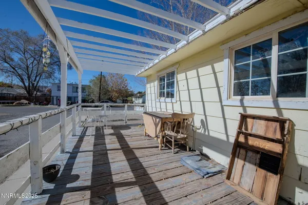 a view of a patio with table and chairs with wooden floor and fence