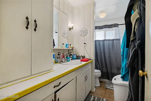 a bathroom with a sink a toilet and shower curtain