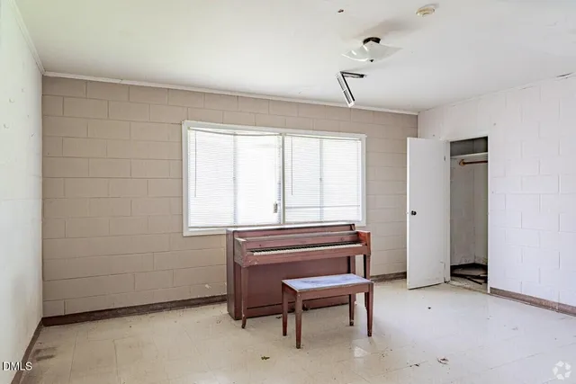 an empty room with windows and closet