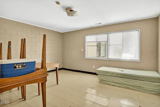 a livingroom with workspace chair and a refrigerator