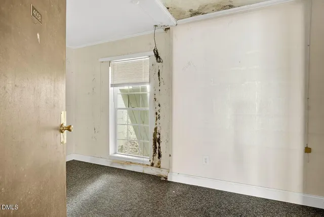 an empty room with windows and sink