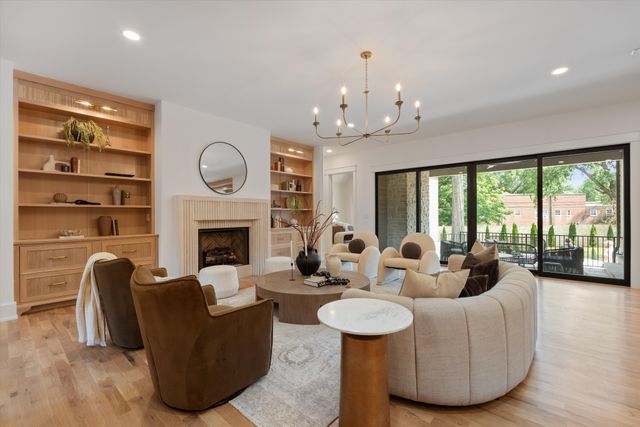a living room with furniture a fireplace and a large window