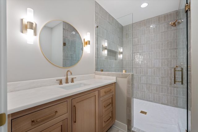 a bathroom with a sink a vanity a mirror and a shower