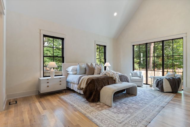 a spacious bedroom with a bed and glass window