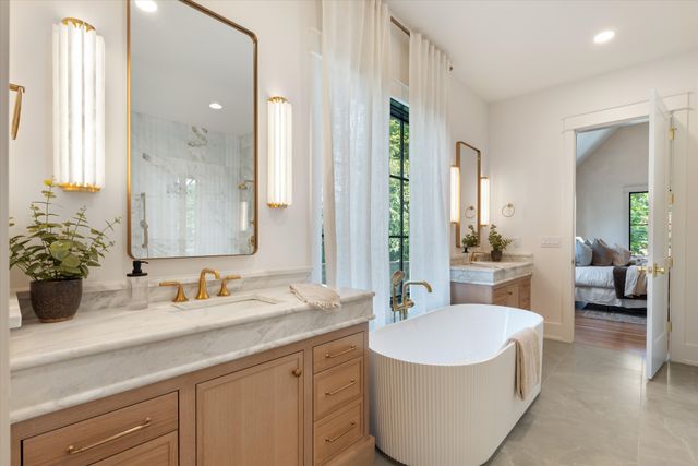 a spacious bathroom with a tub sink and mirror