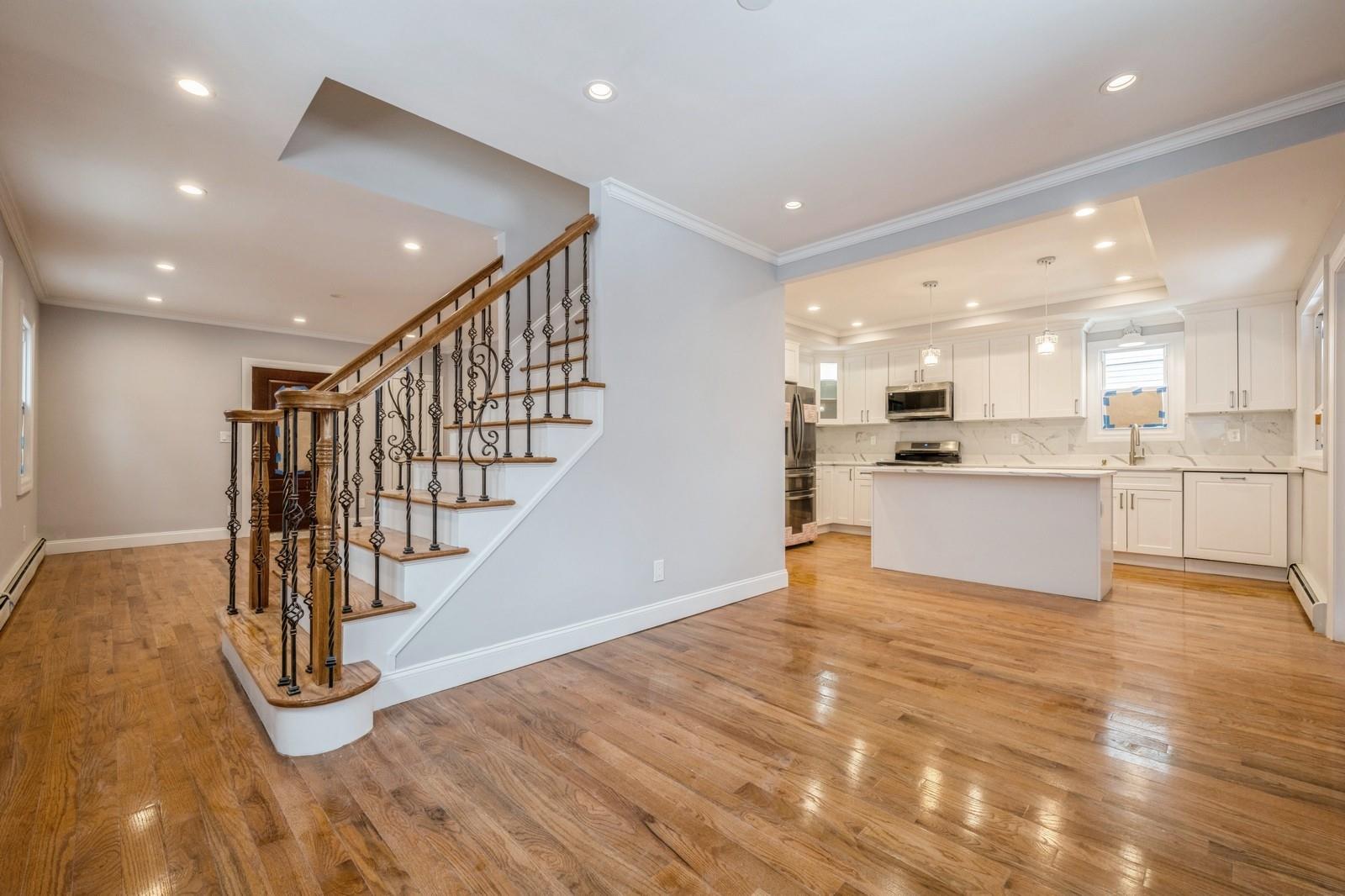 246-59 86th Road Queens, NY 11426 - Photo 12 of 44 Kitchen with tasteful backsplash, appliances with stainless steel finishes, a center island, and white cabinets