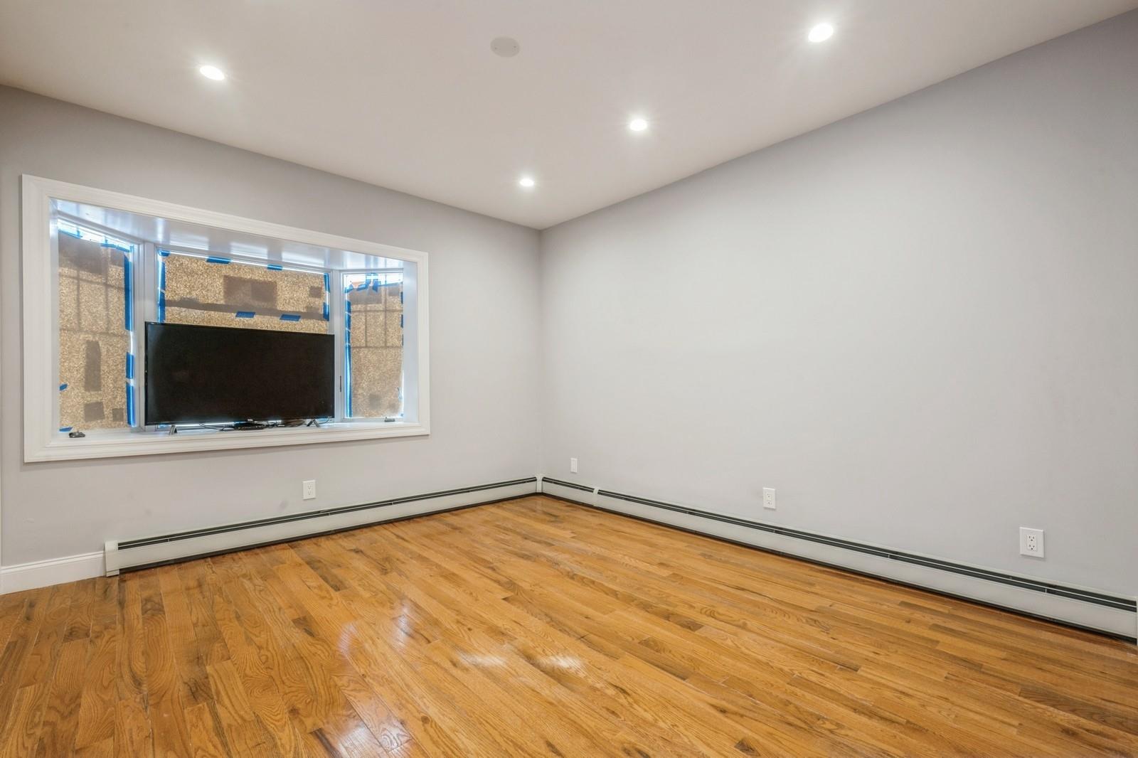 246-59 86th Road Queens, NY 11426 - Photo 20 of 44 Empty room featuring a baseboard radiator and light hardwood / wood-style floors