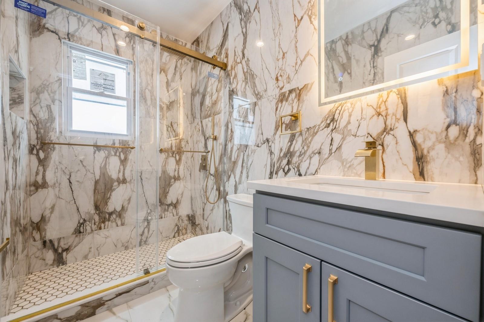 246-59 86th Road Queens, NY 11426 - Photo 22 of 44 Bathroom with vanity, a shower with shower door, and toilet