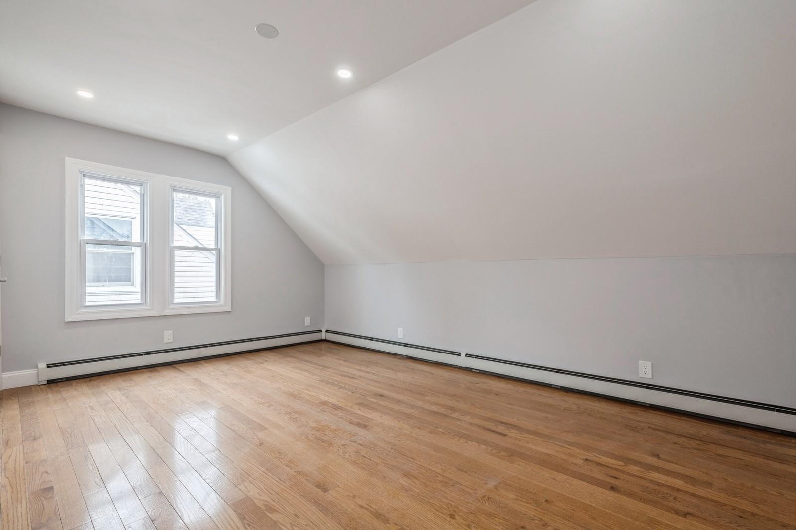246-59 86th Road Queens, NY 11426 - Photo 23 of 44 Bonus room with baseboard heating, vaulted ceiling, and light wood-type flooring