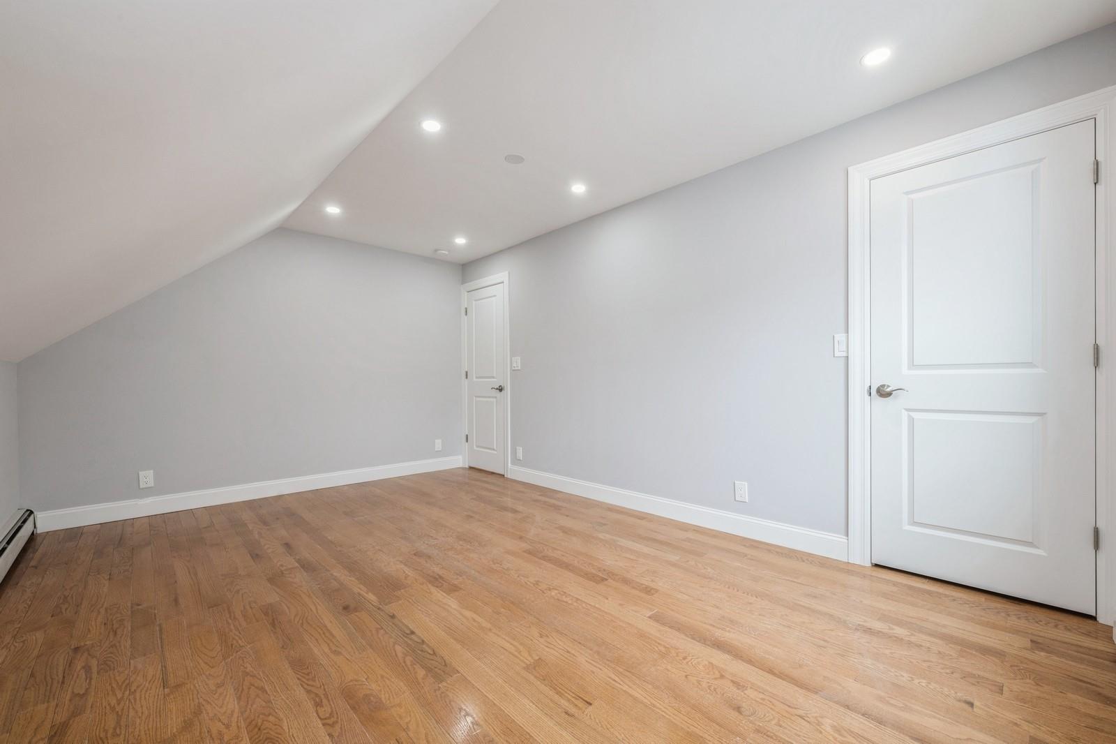 246-59 86th Road Queens, NY 11426 - Photo 24 of 44 Additional living space with lofted ceiling, light hardwood / wood-style flooring, and a baseboard radiator