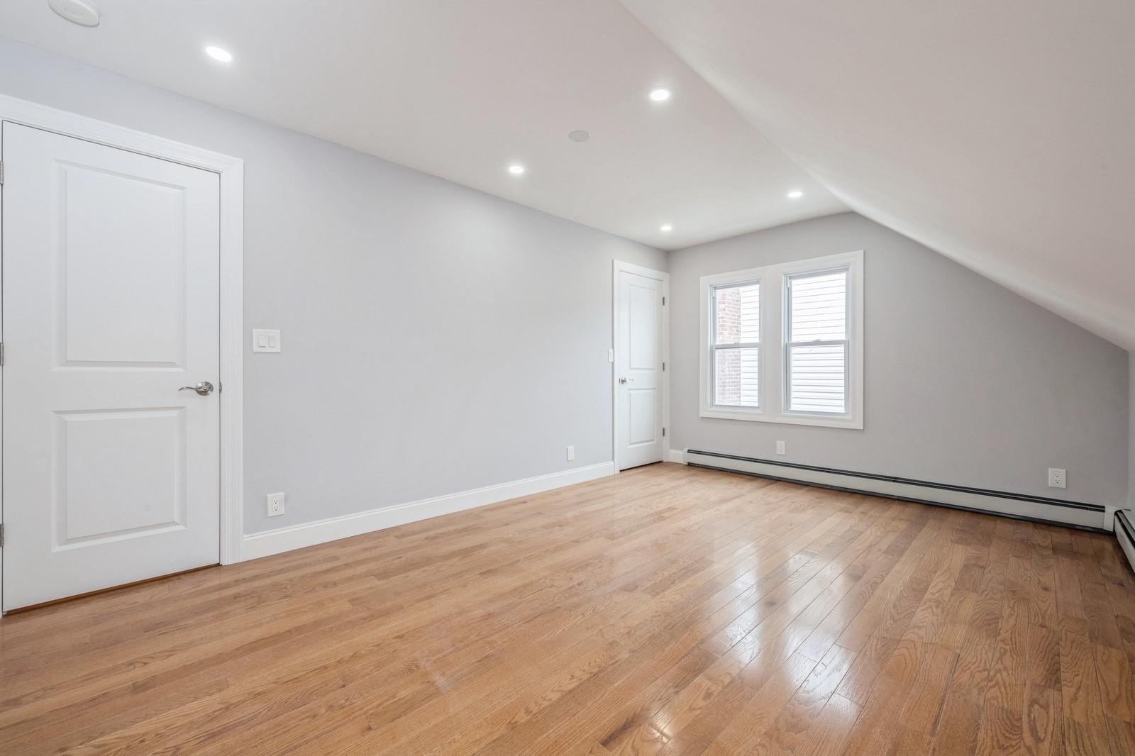 246-59 86th Road Queens, NY 11426 - Photo 25 of 44 Bonus room featuring a baseboard radiator, lofted ceiling, and light hardwood / wood-style flooring