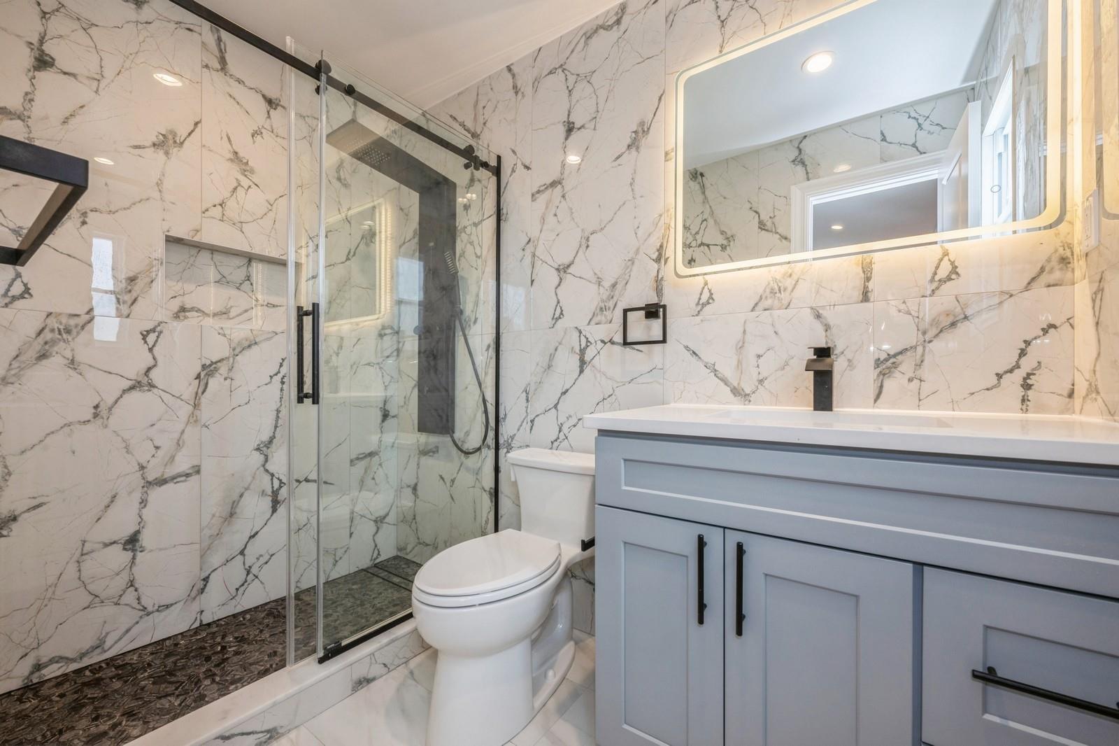 246-59 86th Road Queens, NY 11426 - Photo 32 of 44 Bathroom featuring vanity, a shower with door, and toilet