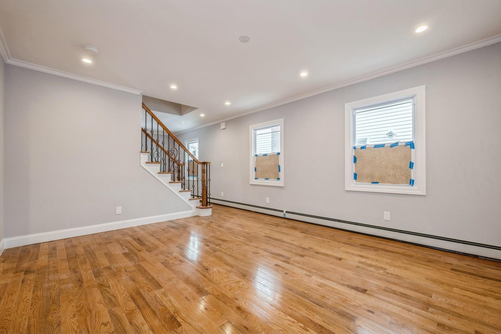246-59 86th Road Queens, NY 11426 - Photo 6 of 44 Unfurnished room with crown molding, a baseboard heating unit, and light wood-type flooring