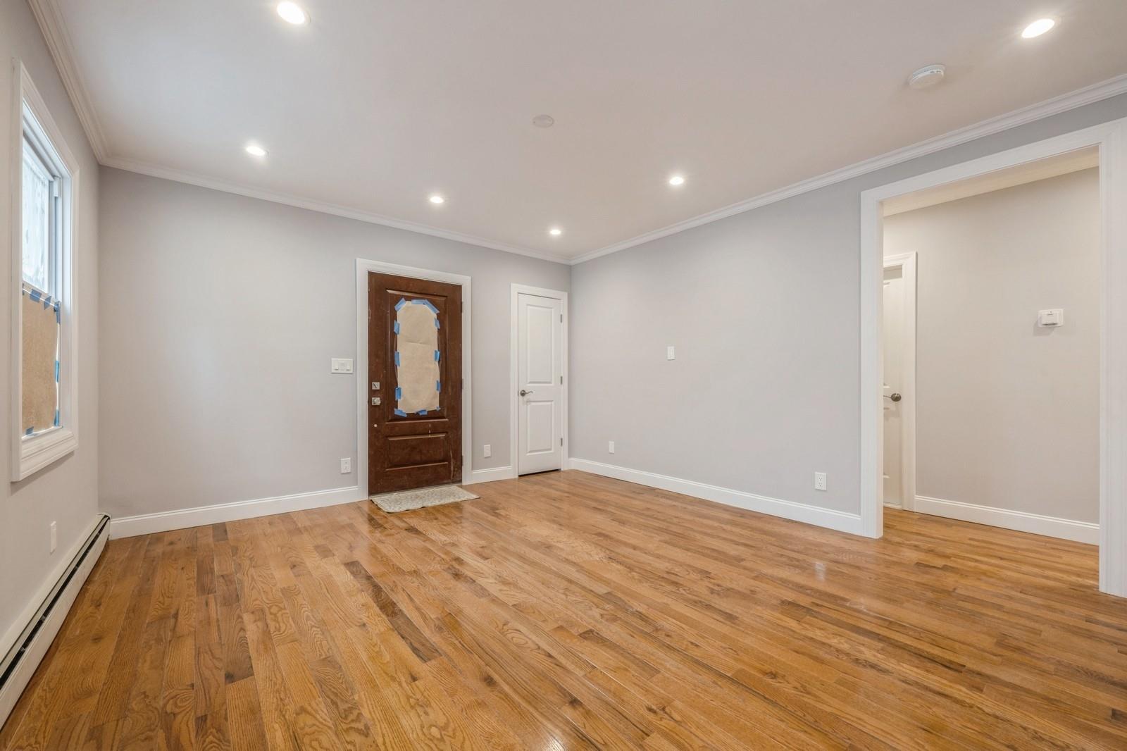 246-59 86th Road Queens, NY 11426 - Photo 7 of 44 Unfurnished room with ornamental molding, light hardwood / wood-style flooring, and a baseboard heating unit