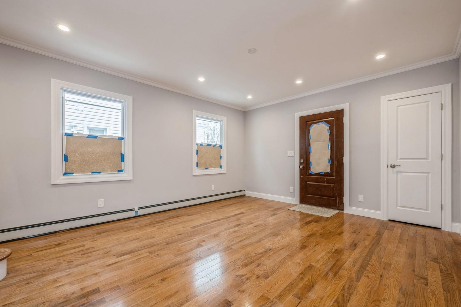246-59 86th Road Queens, NY 11426 - Photo 8 of 44 Spare room with ornamental molding, a baseboard heating unit, and light wood-type flooring