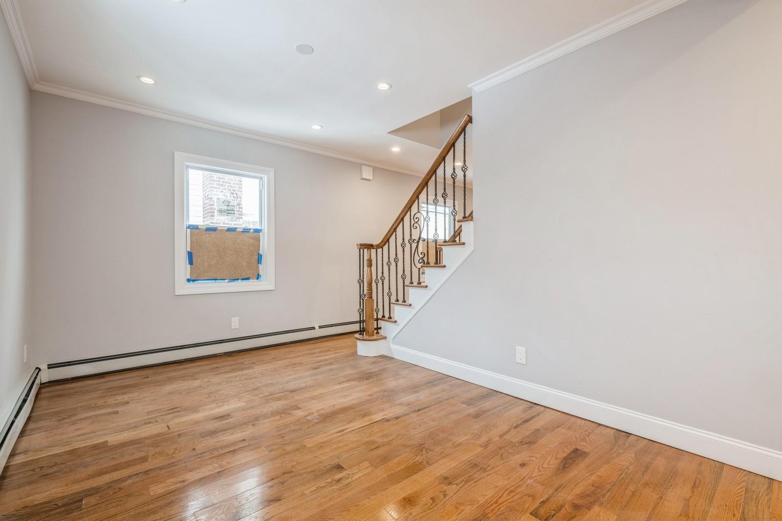 246-59 86th Road Queens, NY 11426 - Photo 10 of 44 Unfurnished room featuring hardwood / wood-style flooring, ornamental molding, and a baseboard heating unit