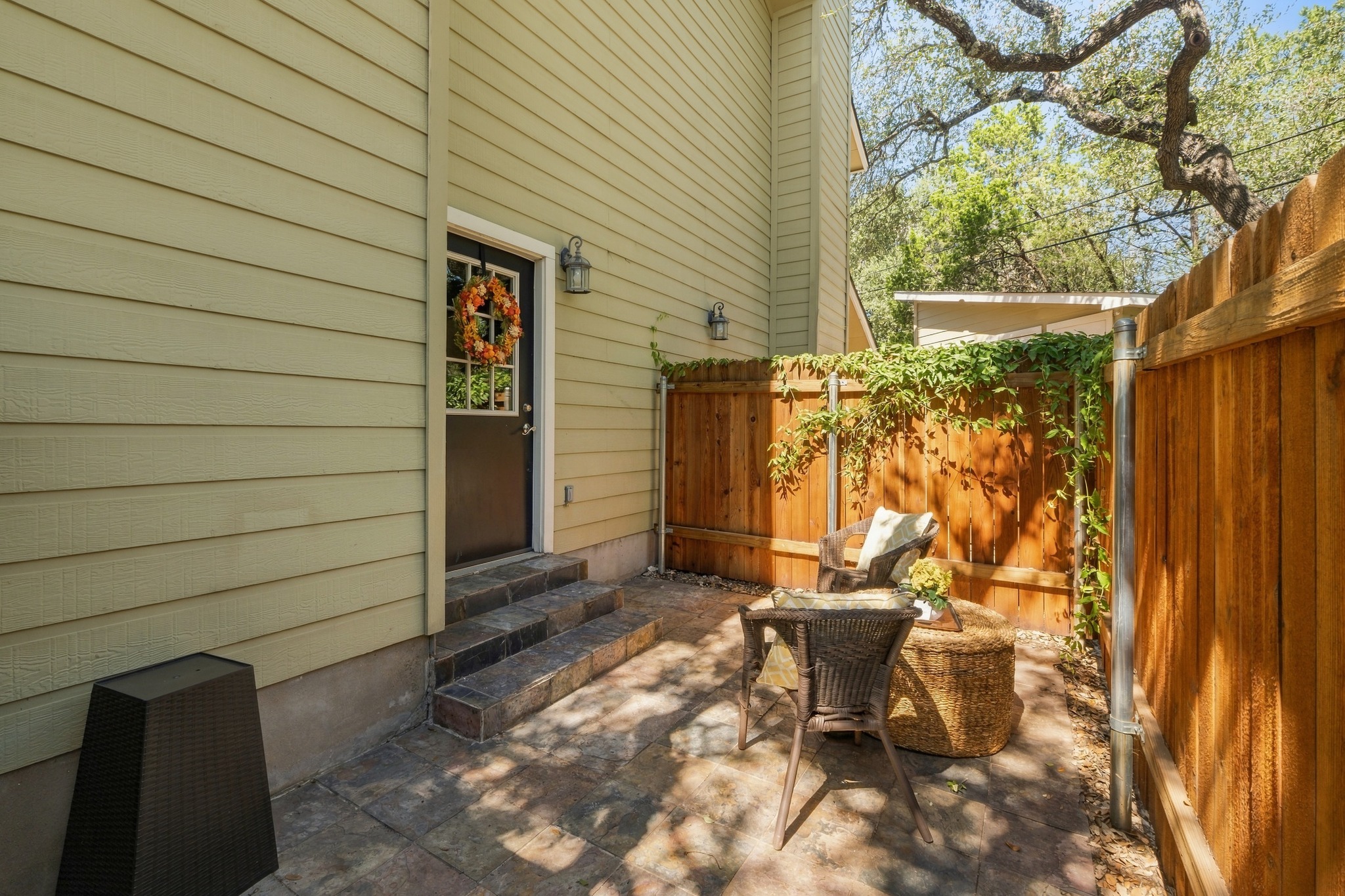 1504 Allen Road, Unit B Austin, TX 78746 - Photo 23 of 24 A private stone courtyard offers a secluded outdoor retreat enclosed by warm wood fencing.