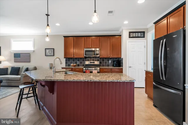 a kitchen with stainless steel appliances granite countertop a sink refrigerator and cabinets