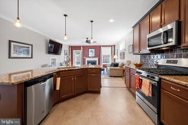 a kitchen with stainless steel appliances granite countertop a stove top oven a sink dishwasher a dining table and chairs