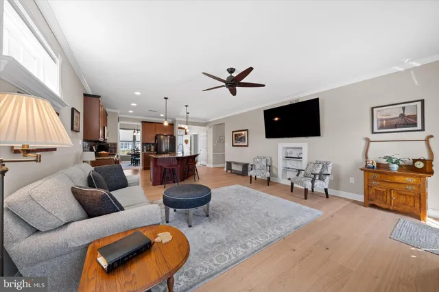 a living room with furniture a flat screen tv and kitchen view