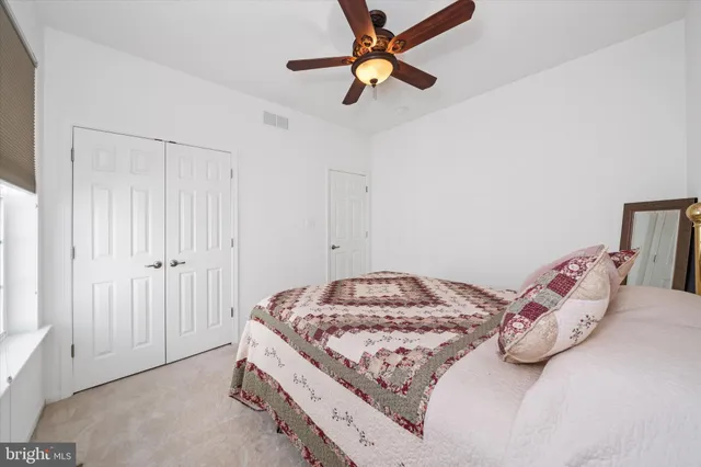 a bedroom with a bed and a chandelier fan