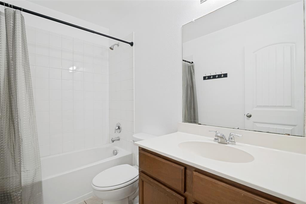 3415 Emerson Road Forney, TX 75126 - Photo 10 of 26 a bathroom with a sink a toilet and a large mirror