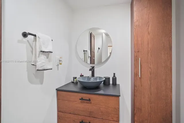 a bathroom with a sink vanity and mirror