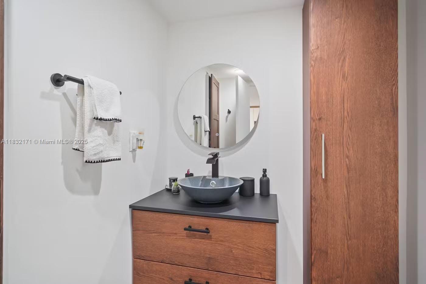 1901 Brickell Avenue, Unit B1706 Miami, FL 33129 - Photo 11 of 15 a bathroom with a sink vanity and mirror