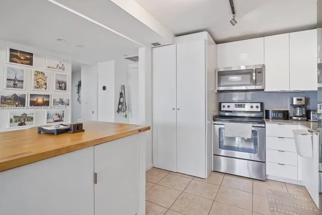 a kitchen with stainless steel appliances a sink stove and cabinets