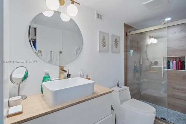 a bathroom with a sink a toilet and a mirror