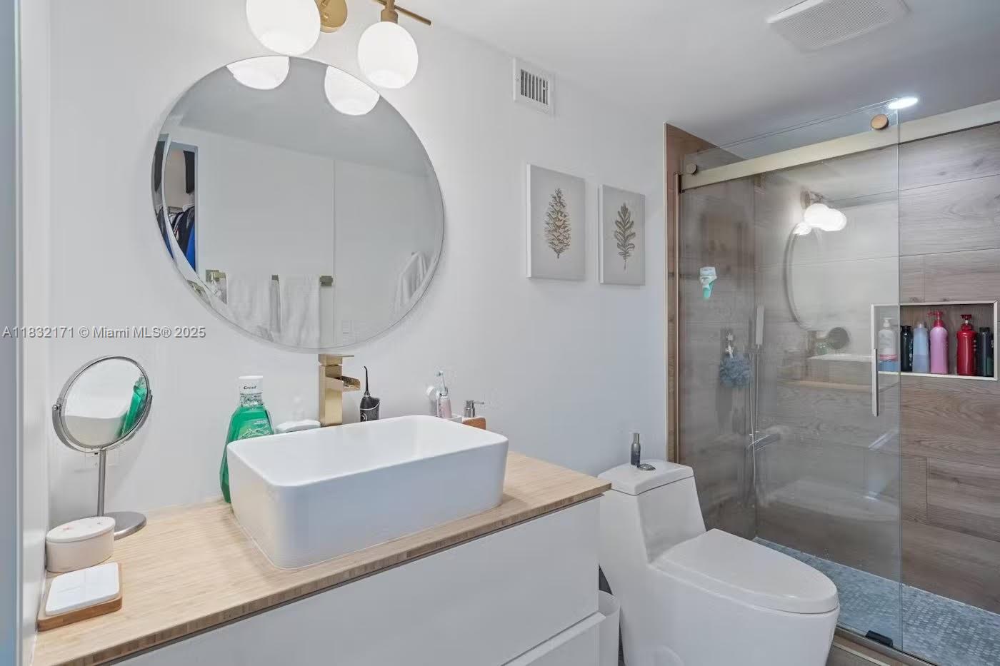 1901 Brickell Avenue, Unit B1706 Miami, FL 33129 - Photo 9 of 15 a bathroom with a sink a toilet and a mirror