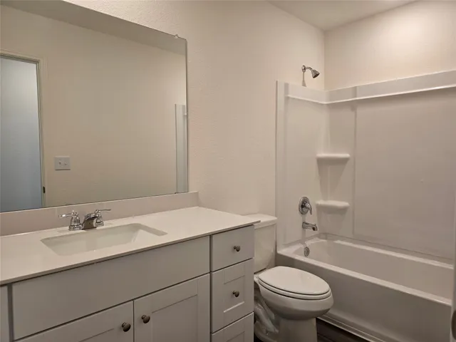 a bathroom with a sink toilet vanity and tub