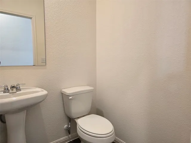 a white toilet sitting next to a bathroom sink