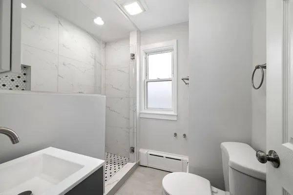 a bathroom with a toilet sink and mirror