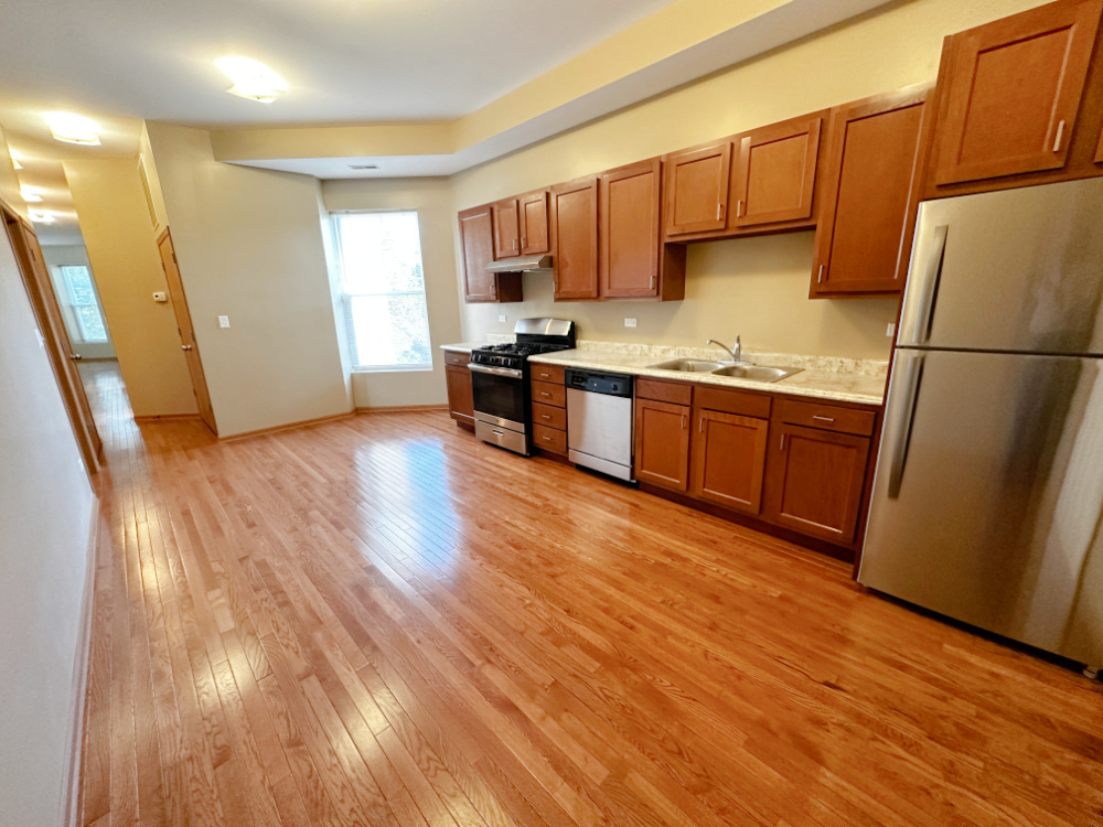 639 West Garfield Boulevard, Unit 3 Chicago, IL 60621 - Photo 2 of 13 a kitchen with stainless steel appliances granite countertop a refrigerator a sink dishwasher and wooden cabinets with wooden floor