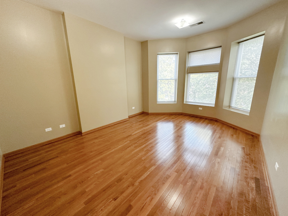 639 West Garfield Boulevard, Unit 3 Chicago, IL 60621 - Photo 4 of 13 an empty room with wooden floor and windows