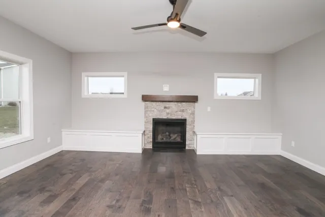 wooden floor fireplace and windows in an empty room