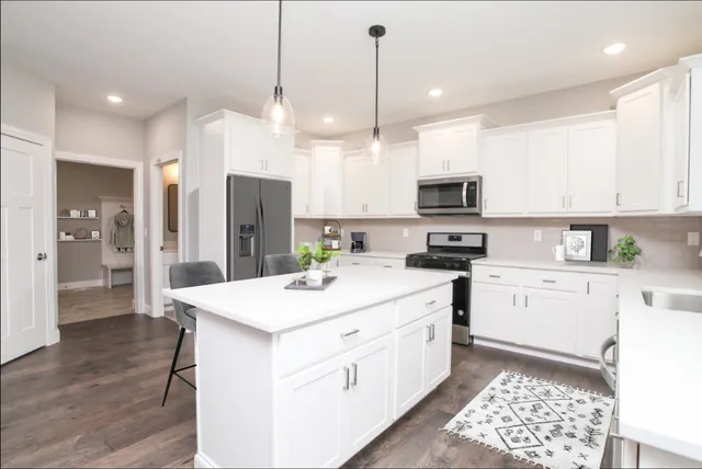 a kitchen with a sink a counter top space stainless steel appliances and cabinets