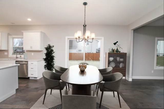 a dining room with furniture a chandelier and wooden floor