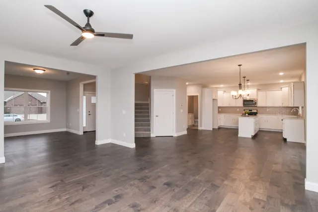 a view of an empty room and kitchen view