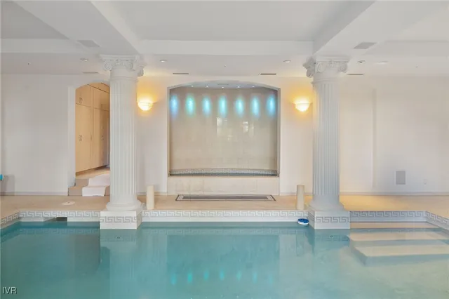 a bath room with a toilet a sink and a large mirror