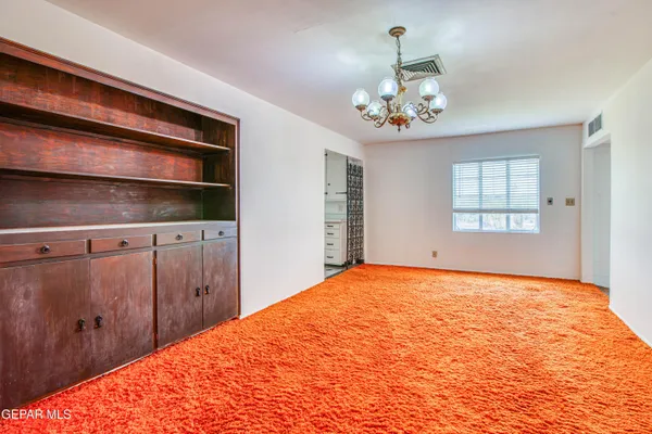 a view of a hallway with wooden floor and a bathroom
