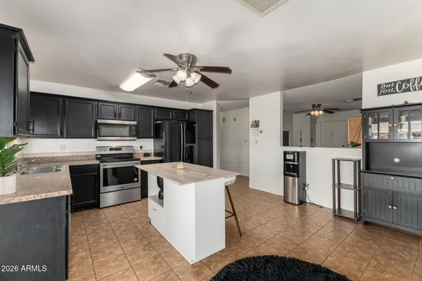 a kitchen with stainless steel appliances kitchen island a cabinets and a fireplace