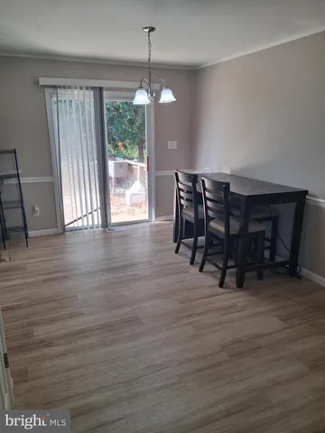 a kitchen view with stainless steel appliances refrigerator dining table and chairs