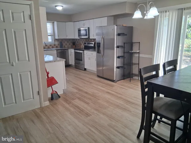 a kitchen with a refrigerator a sink and a stove top oven