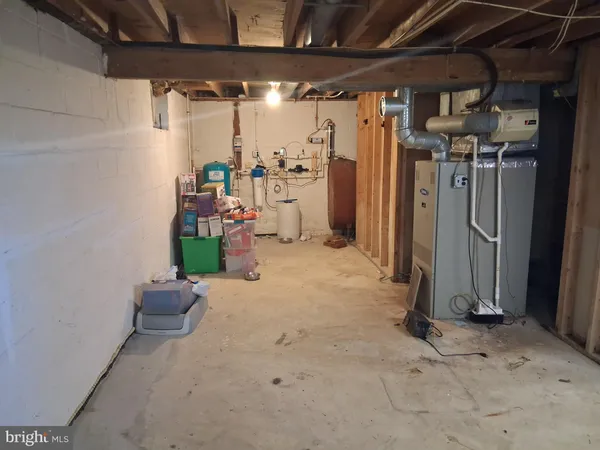 a room with water heater and a wooden cabinets
