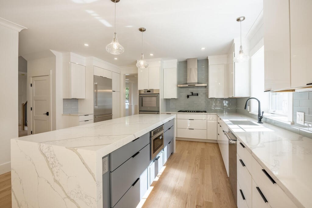 526 Marrett Road Lexington, MA 02421 - Photo 11 of 37 a large white kitchen with kitchen island a sink a stove a refrigerator and a cabinets